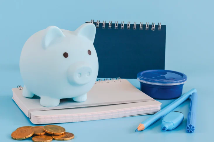 Porquinho mealheiro sobre material escolar