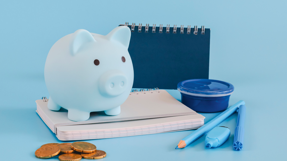 Porquinho mealheiro sobre material escolar