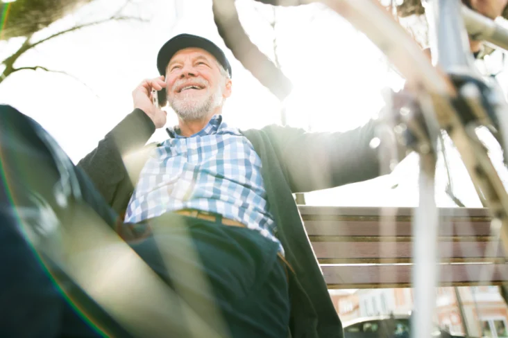 Reformado sentado perto da sua bicicleta