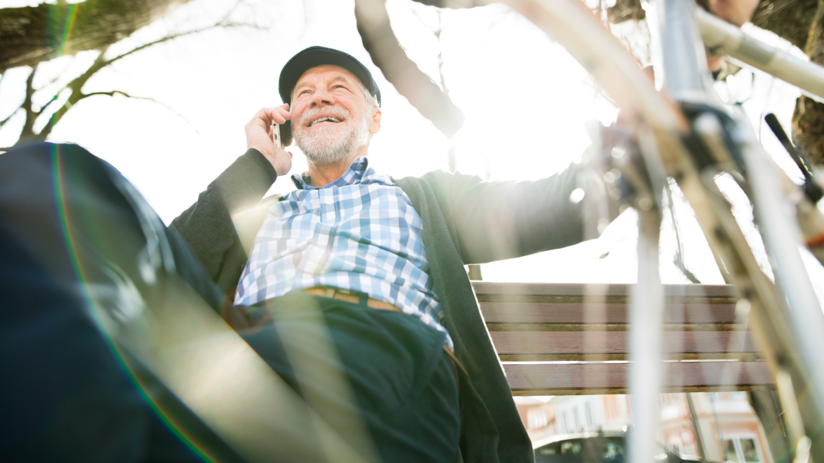 Reformado sentado perto da sua bicicleta