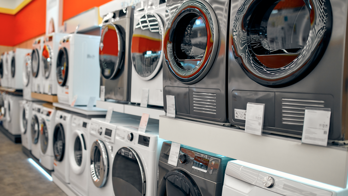 Várias máquinas de lavar roupa, novas, numa loja de eletrodomésticos