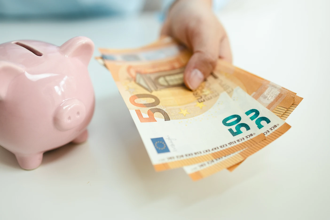 Como poupar dinheiro: 7 medidas que rendem 5.000 euros Imagem onde um homem segura em várias notas de cinquenta euros