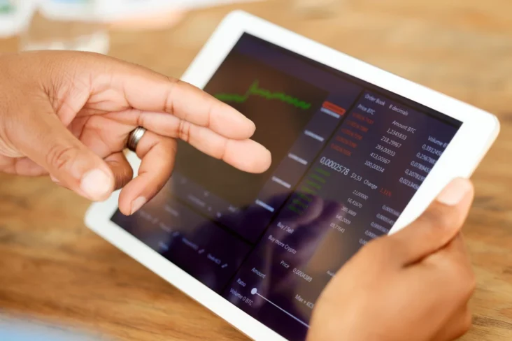 Imagem de um homem a usar um tablet para investir