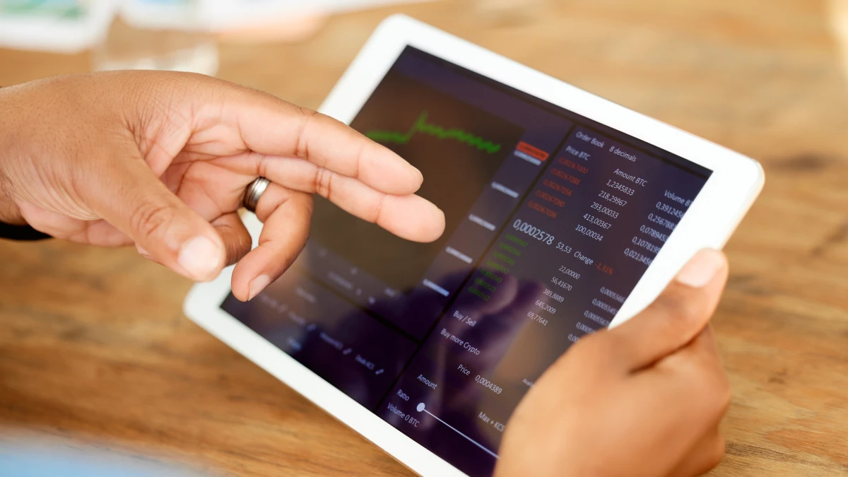 Imagem de um homem a usar um tablet para investir