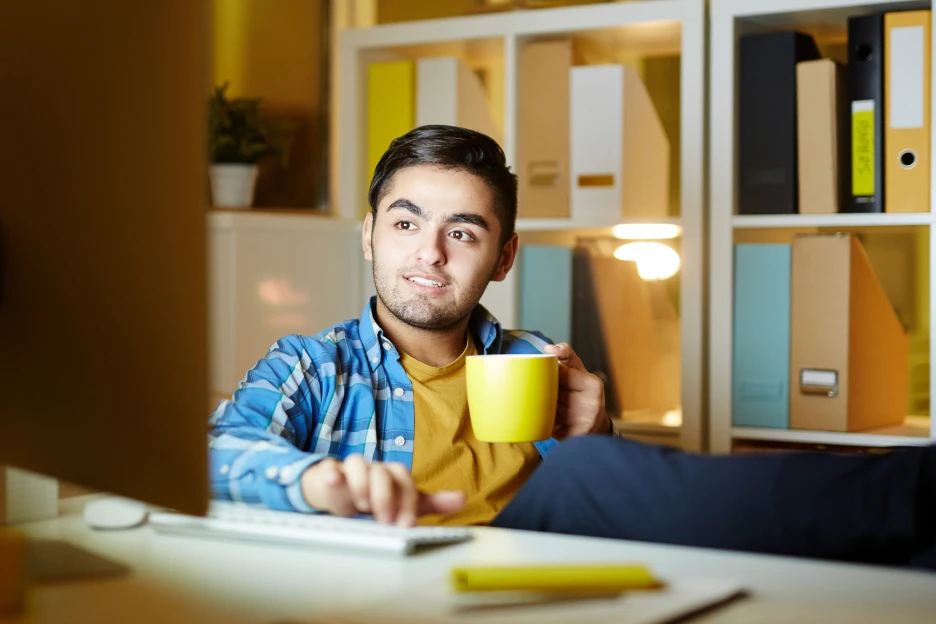 Imagem de um jovem a trabalhar descontraído ao computador