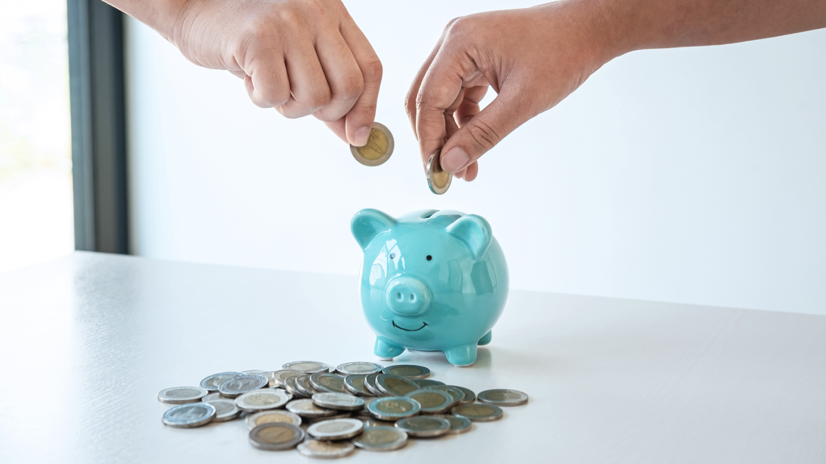 Casal guarda moedas num mealheiro