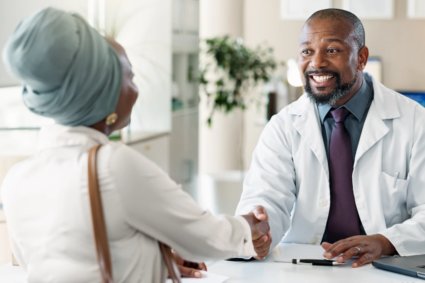 Imagem onde um médico dá um aperto de mão à sua paciente