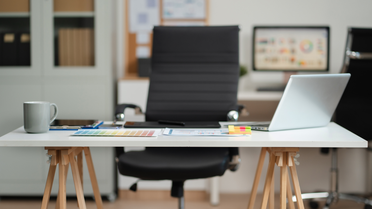 Faltas justificadas vs. injustificadas e respetivo impacto no salário Imagem de uma mesa e cadeira de escritório sem ninguém sentado a trabalhar