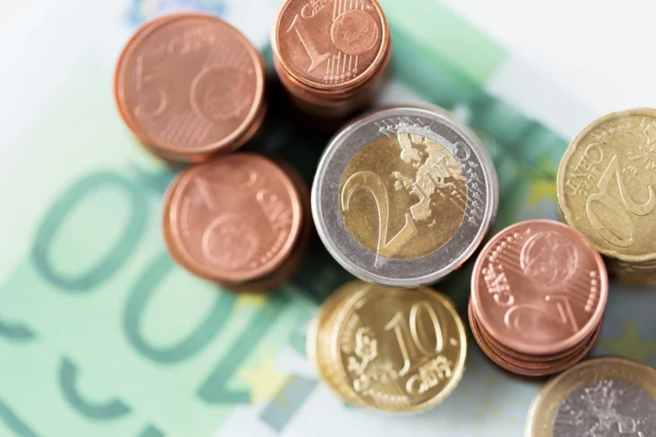 Várias moedas de euro sobre notas de 100 euros