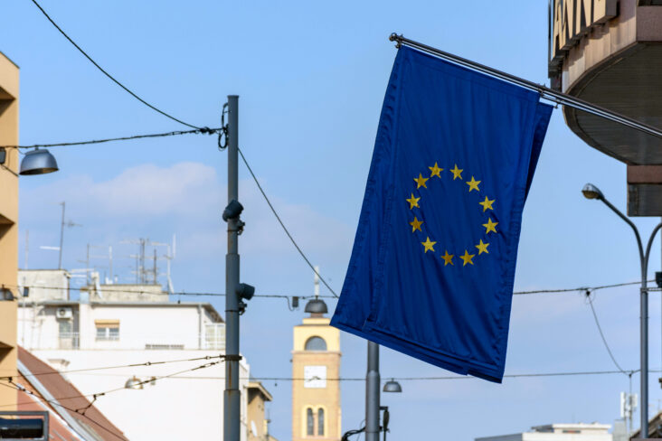Bandeira da União Europeia pendurada num edifício, numa altura em que os preços das casas continuam a aumentar um pouco por toda a região