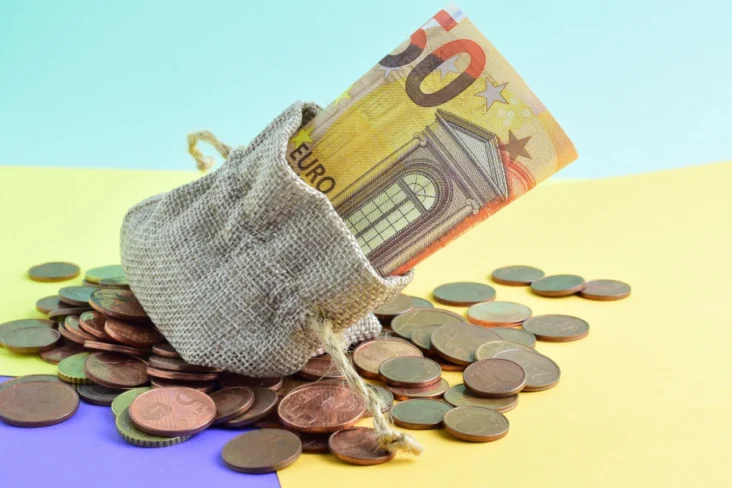 Imagem de uma bolsa com notas e moedas de euro