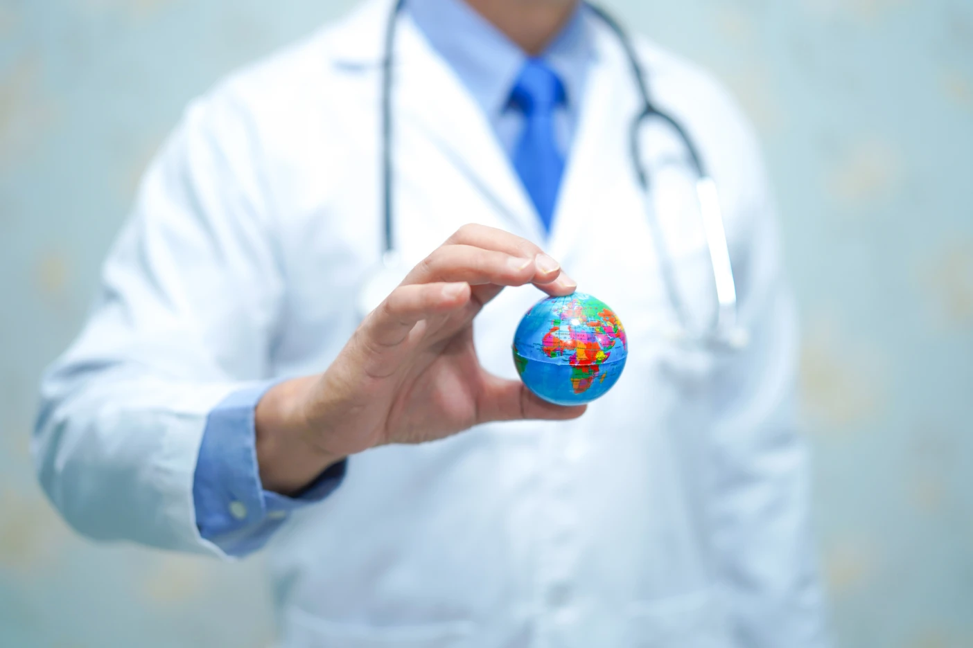 Imagem onde um médico segura um globo terrestre