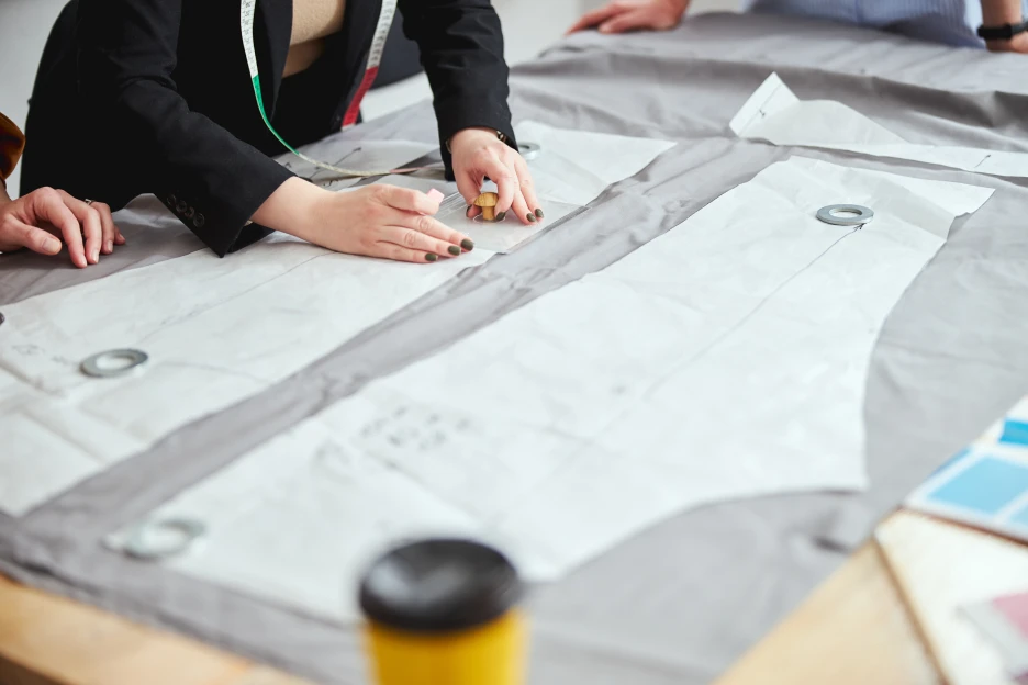 Imagem onde uma costureira planeia o corte de umas calças, exemplo de empreendedorismo na área da moda