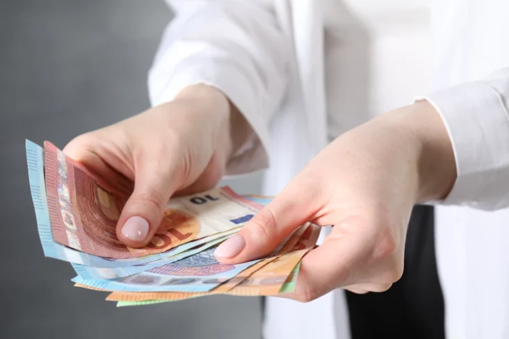 Imagem onde uma mulher conta dinheiro em notas de euros