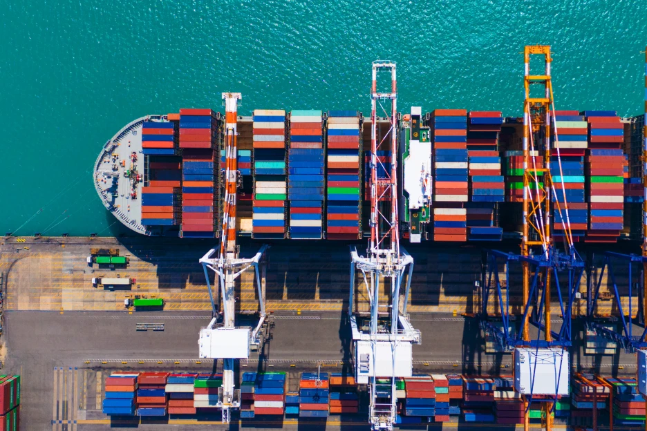 Imagem de um navio cargueiro atracado num porto para receber contentores