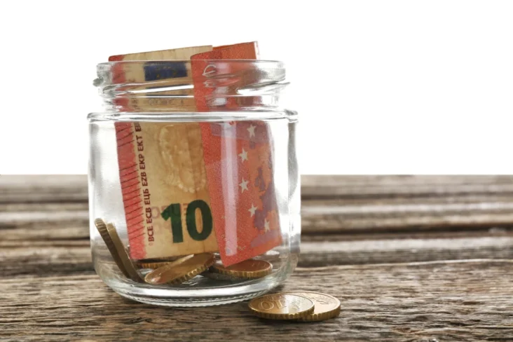 Imagem de notas e moedas numa poupança