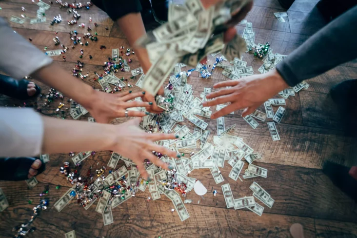 Várias mãos a agarrar notas de dólar