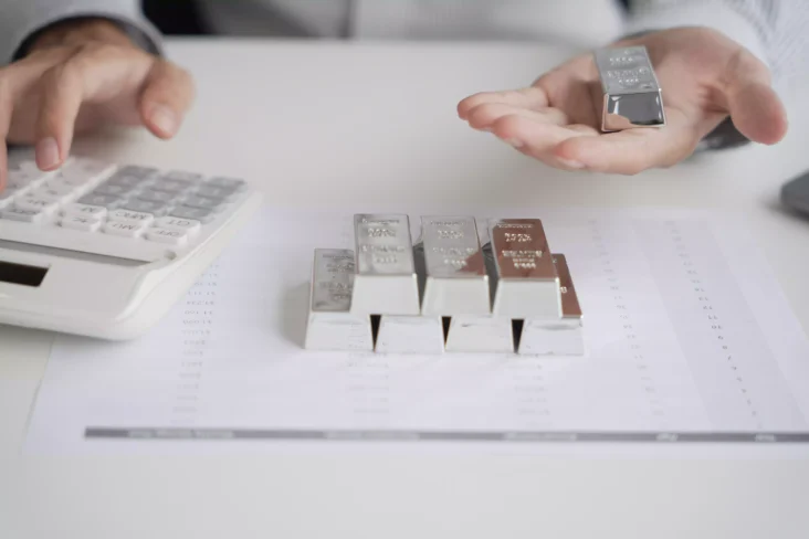 homem segura barras de prata