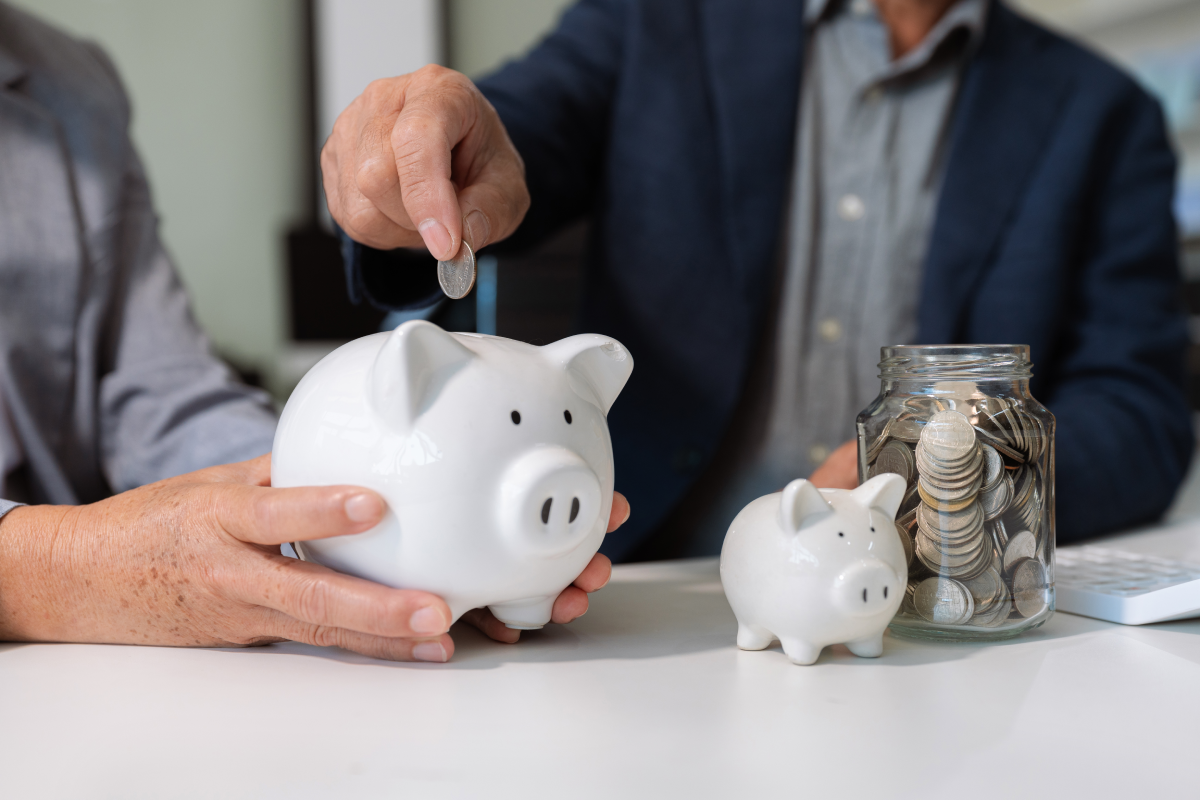 Duas pessoas com porquinhos mealheiros a ilustrar o investimento num ppr com capital garantido e num PPR em fundos