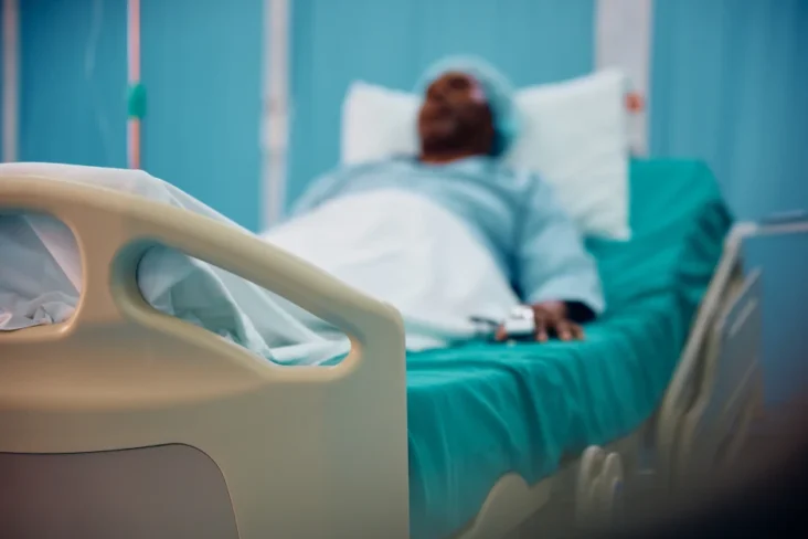 Imagem de um homem numa cama de hospital com uma doença grave