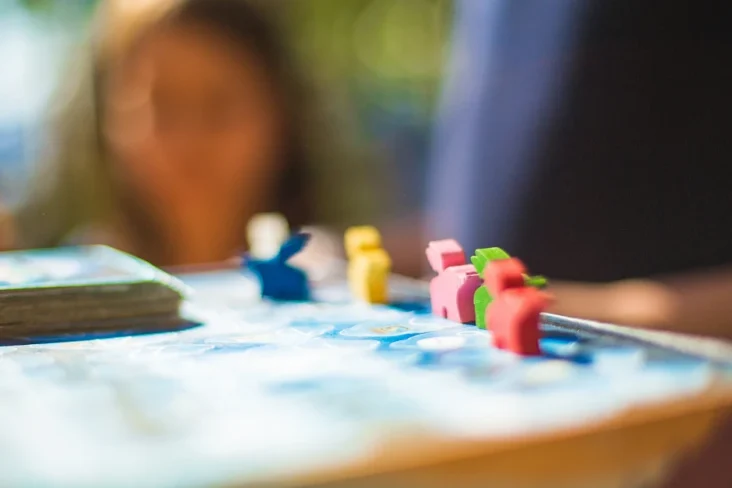 Imagem de um jogo de tabuleiro com notas e peças de peões