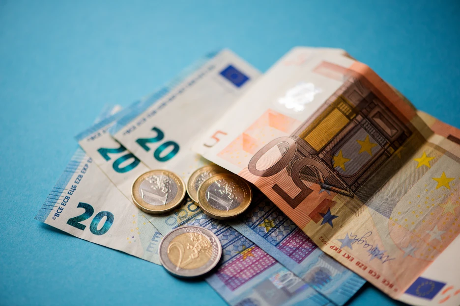 Imagem de notas e moedas sobre fundo azul