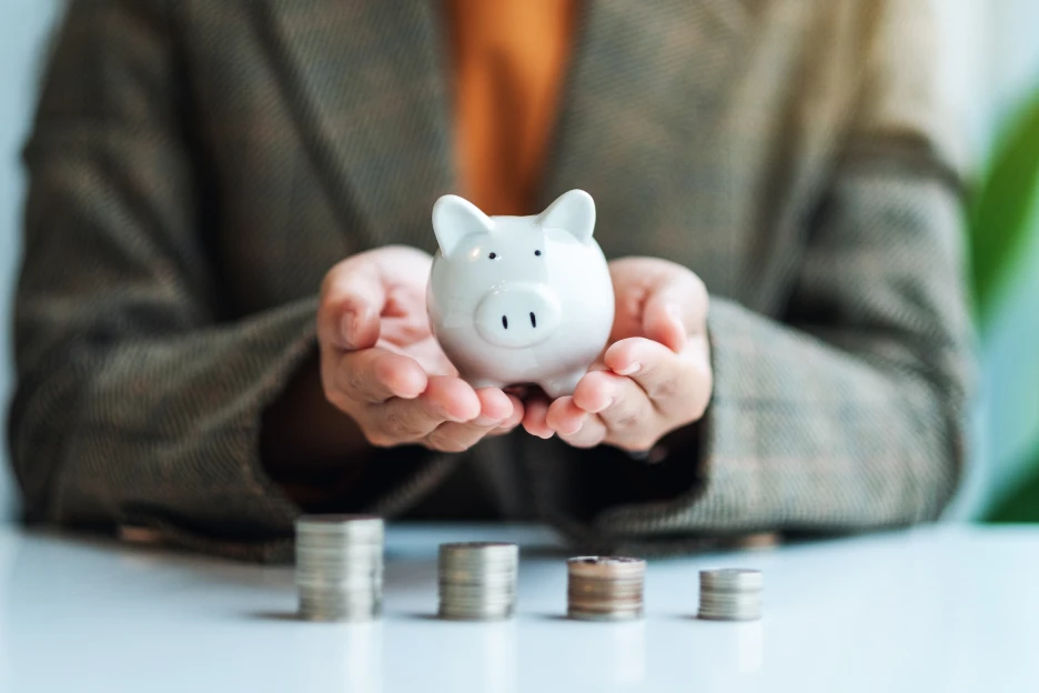 Imagem onde uma mulher segura num porco mealheiro onde guarda dinheiro