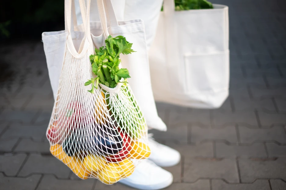 Imagem de uma mulher a utilizar sacos reutilizáveis para as suas compras