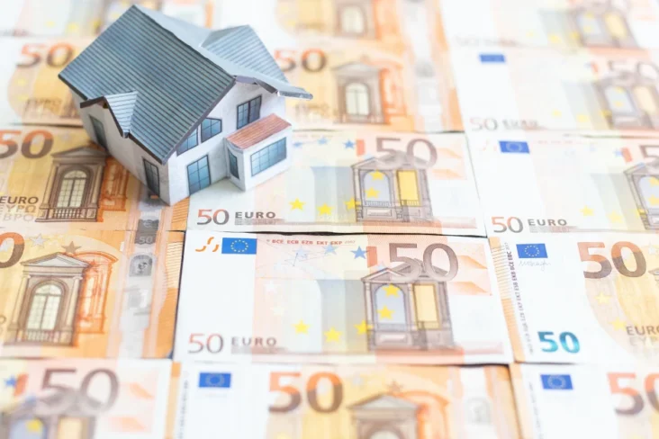 Imagem de uma casa de brincar sobre notas de euro