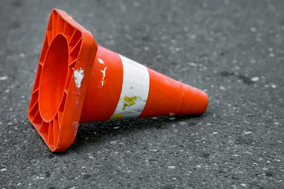 Imagem de um cone de estrada tombado, representativo de mau tempo e estradas cortadas