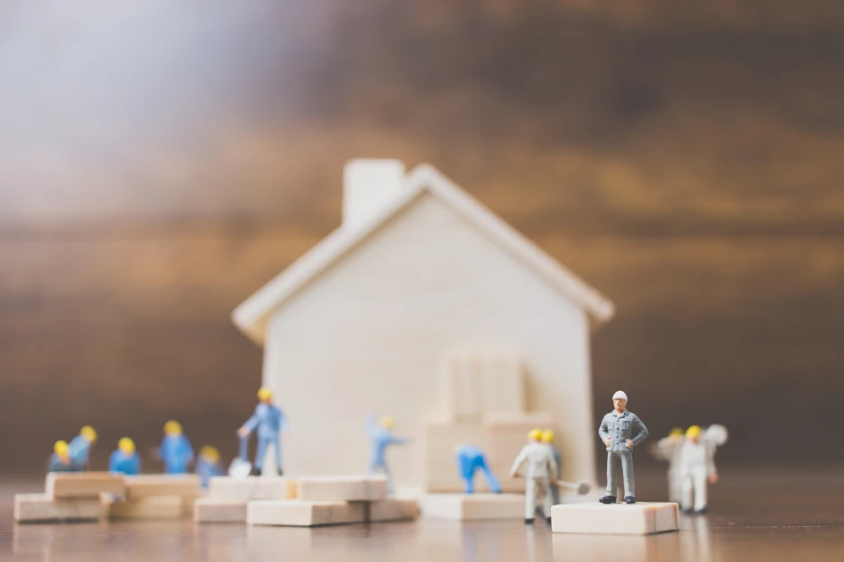Vai fazer uma obra? Saiba como funciona o processo urbanístico na câmara municipal Imagem de personagens miniatura a trabalhar numa casa