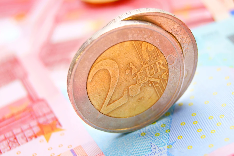 Imagem de moedas e notas de euro, num ângulo que implica crescimento