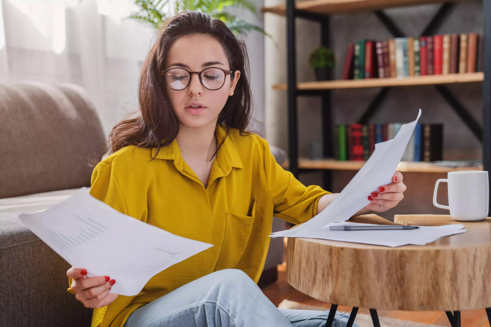 Habitação Própria Permanente: O que é e como se comprova? Jovem em casa a ver documentos