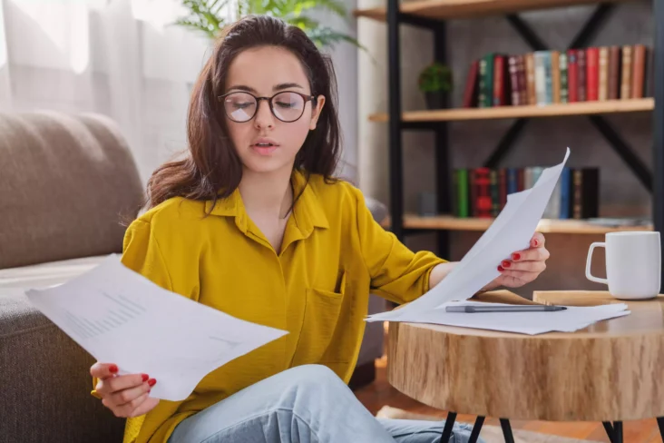 Jovem em casa a ver documentos