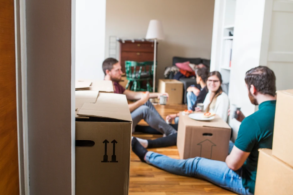 Imagem de amigos jovens adultos a mudarem-se para uma casa em conjunto