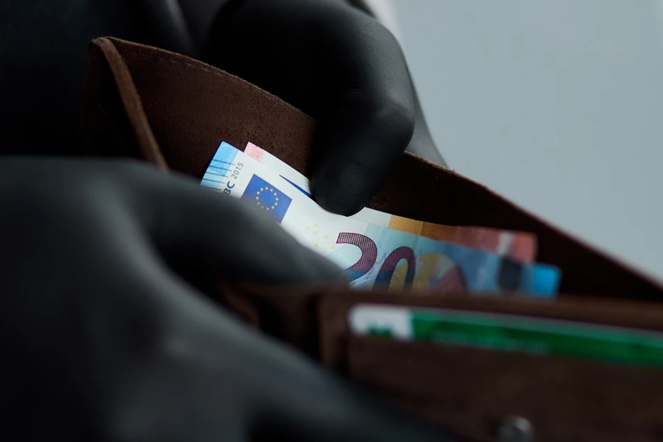 Ser um aldrabão bem-sucedido (e sem remorsos) Imagem de um ladrão, de luvas pretas de latex, a retirar dinheiro de uma carteira