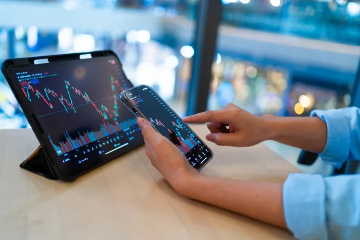 Imagem onde uma mulher utiliza plataformas de investimento online numa aplicação de telemóvel