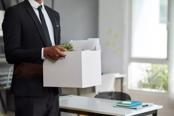 Homem a carregar caixa com pertences no escritório