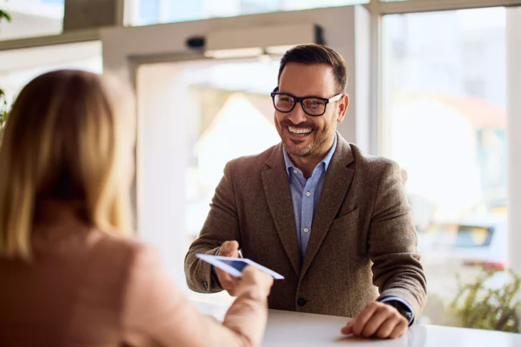 Homem sorridente a ser atendido no banco