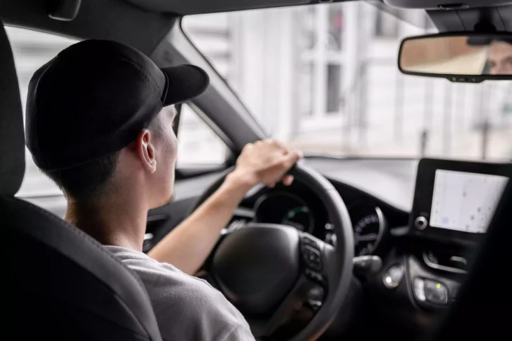 Jovem a conduzir carro