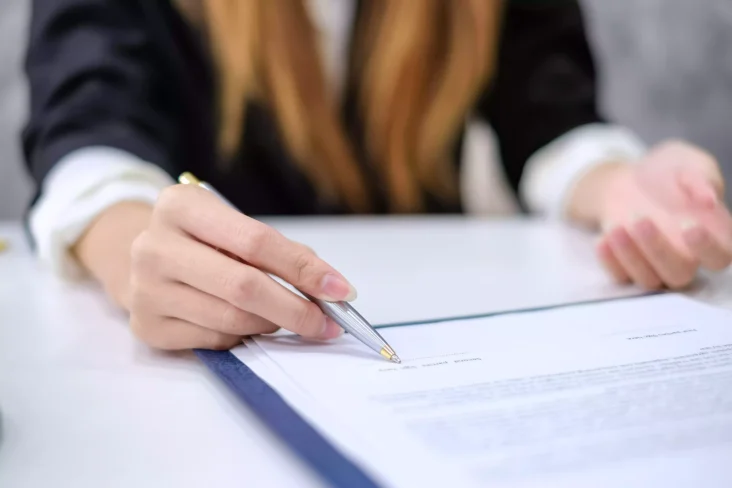 Mulher a assinar um contrato