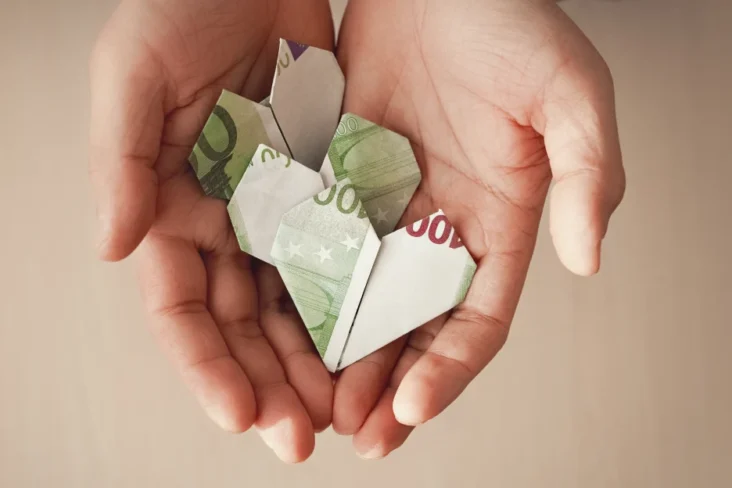 Imagem de um origami com a forma de um coração, feito de notas de cem euros