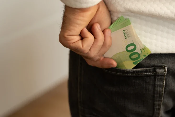 Imagem onde um jovem adulto guarda dinheiro a pensar na sua reforma