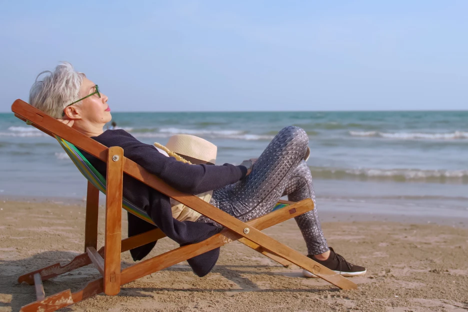 Maioria dos portugueses vê a reforma como “direito conquistado” Imagem onde uma mulher reformada descansa na praia