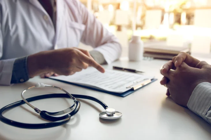 Imagem de um médico a falar com um paciente sobre seguros de saúde