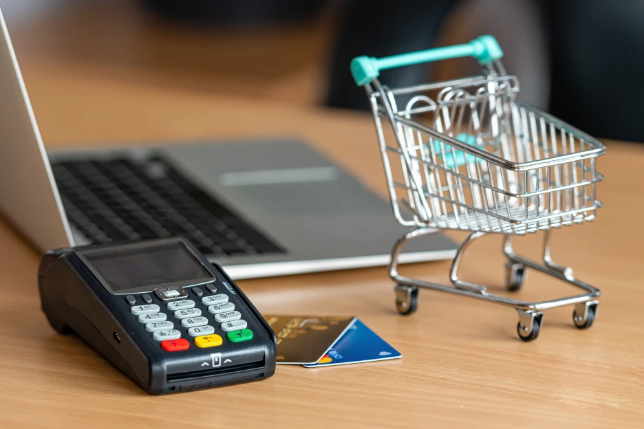 Imagem de um terminal multibanco e um computador, referente a compras online