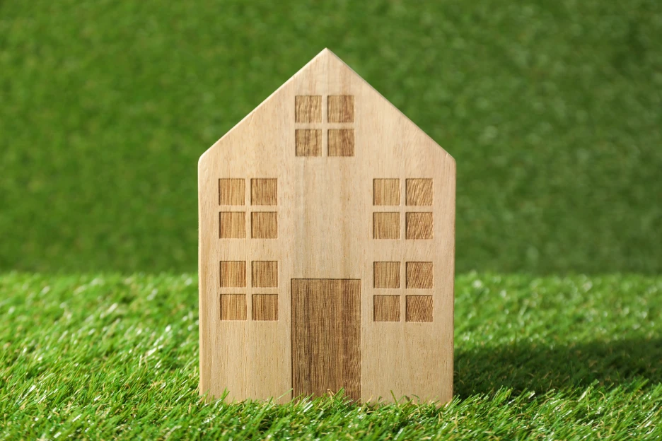 Juros da casa caem em maio para o valor mais baixo em três anos Imagem de um modelo de casa num fundo verde