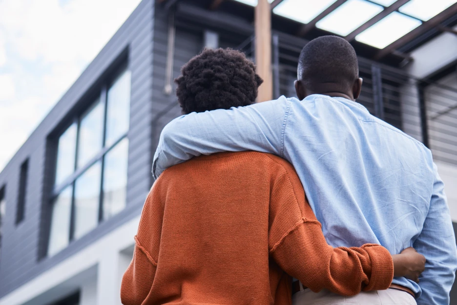 Imagem de uma casal a olhar para a sua casa recém-comprada