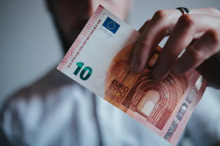 Imagem onde uma figura suspeira segura uma nota de dez euros