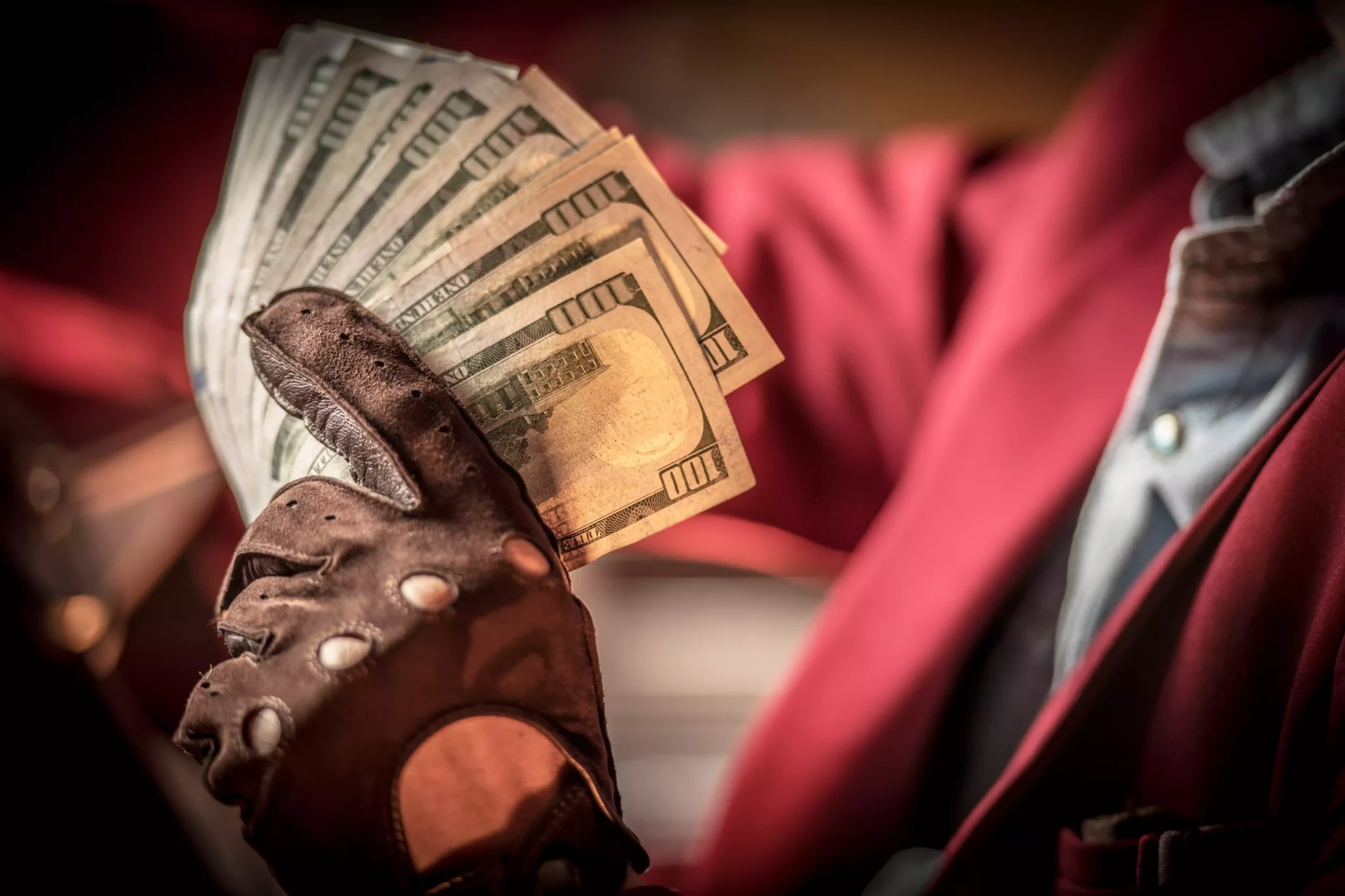 O jogo do dinheiro: Querem mesmo entrar? (vol. I) Homem a guardar notas de dólar
